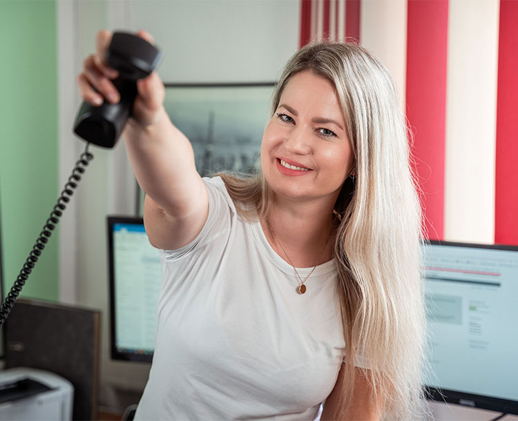 Katharina Besold hält lächelnd den Telefonhörer ins Bild